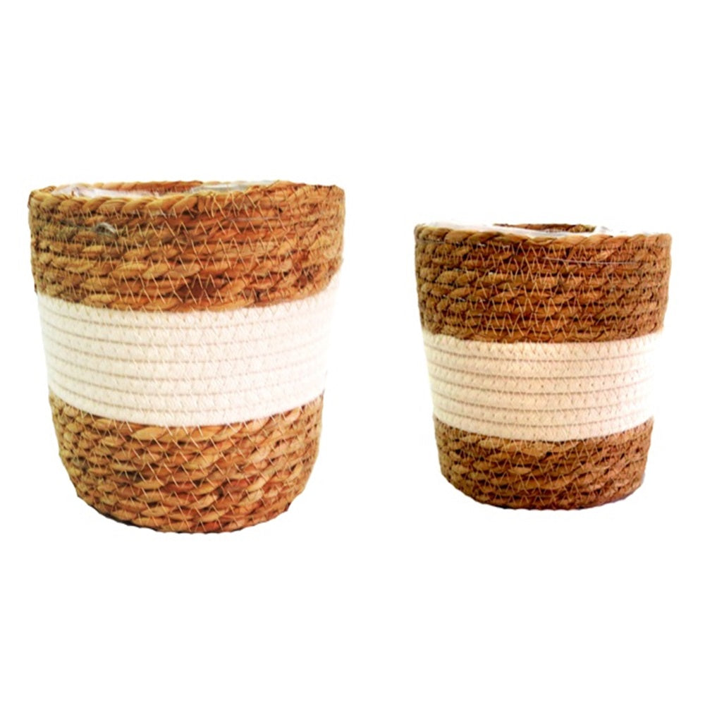 This set of 2 plastic lined baskets features a thick central border of white cotton, creating a fresh and stunning planter set. Each basket is expertly woven in natural materials, with the bigger basket measuring 22.5cm in diameter and 19cm in height, while the smaller one measures 19cm in diameter and 16cm in height. Perfect for holding plants or organizing your home-unique interiors