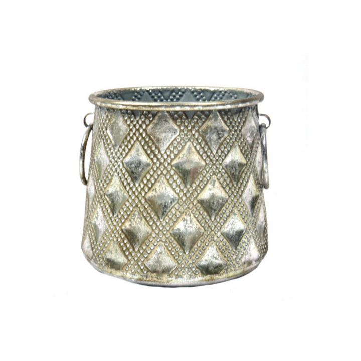 The Manalini Vase is a versatile and attractive addition to any space. Measuring 17.5cm in width and 15.5cm in height, this metal container features a desirable surface pattern and a lovely antique gold finish. It comes with a glass insert for use as a candle lantern, metal vase, or planter. Functional and stylish, it's a must-have for any décor.UNIQUE INTERIORS.