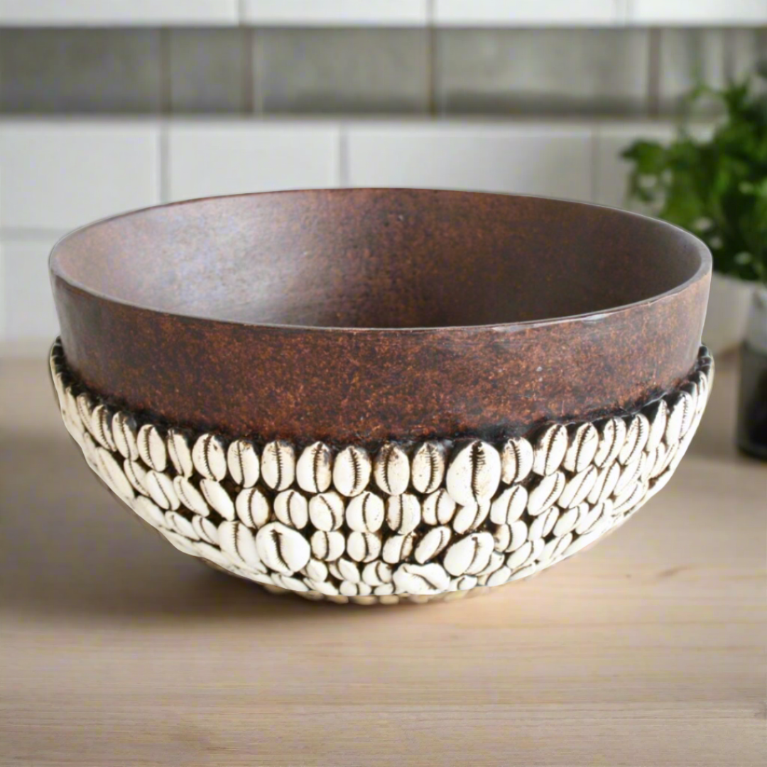 Elevate your decor with our expertly handmade African bowl, featuring an intricate corie shell design. Measuring 14x30cm, this unique piece adds a touch of African culture and supports local artisans. Bring a piece of Africa into your home today. Unique Boys.