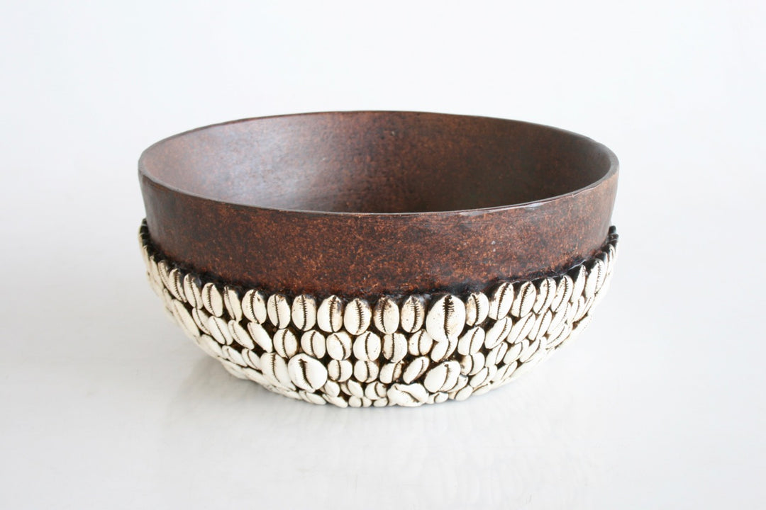 Elevate your decor with our expertly handmade African bowl, featuring an intricate corie shell design. Measuring 14x30cm, this unique piece adds a touch of African culture and supports local artisans. Bring a piece of Africa into your home today. Unique Boys.