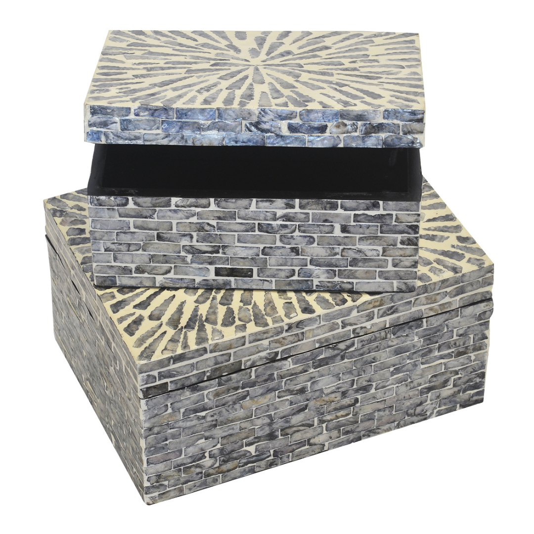 This Mop Box Capiz Grey Brick S/2 is sure to add an instant touch of style to any home. Its unique design stands out with two differently sized boxes - 30cm x 22cm x 15cm and 25cm x 17cm x 12cm - making it a must-have addition to your decor. Its design makes it ideal for storing and displaying any accessories.  Mop box capiz grey brick s/2